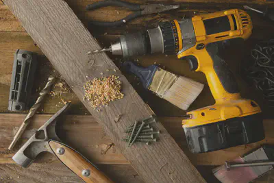 A person lending a drill to a neighbor at the door